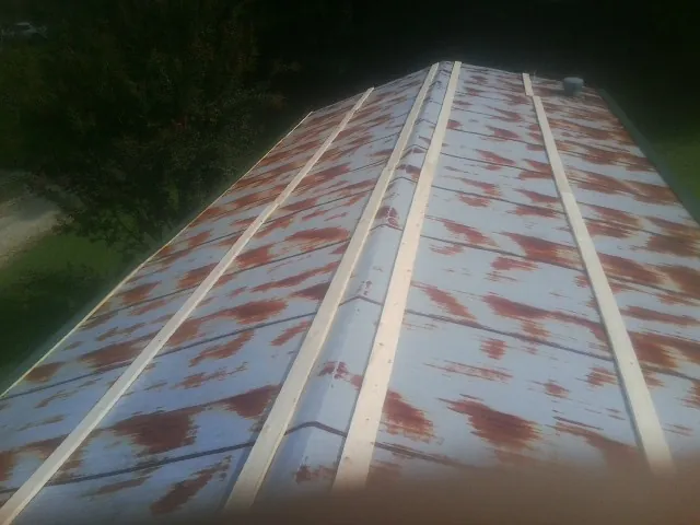 Rusted metal roof panels with new wood purlins before replacement — Storm Damage Roof Repair in Zeigler by Roofing Brothers