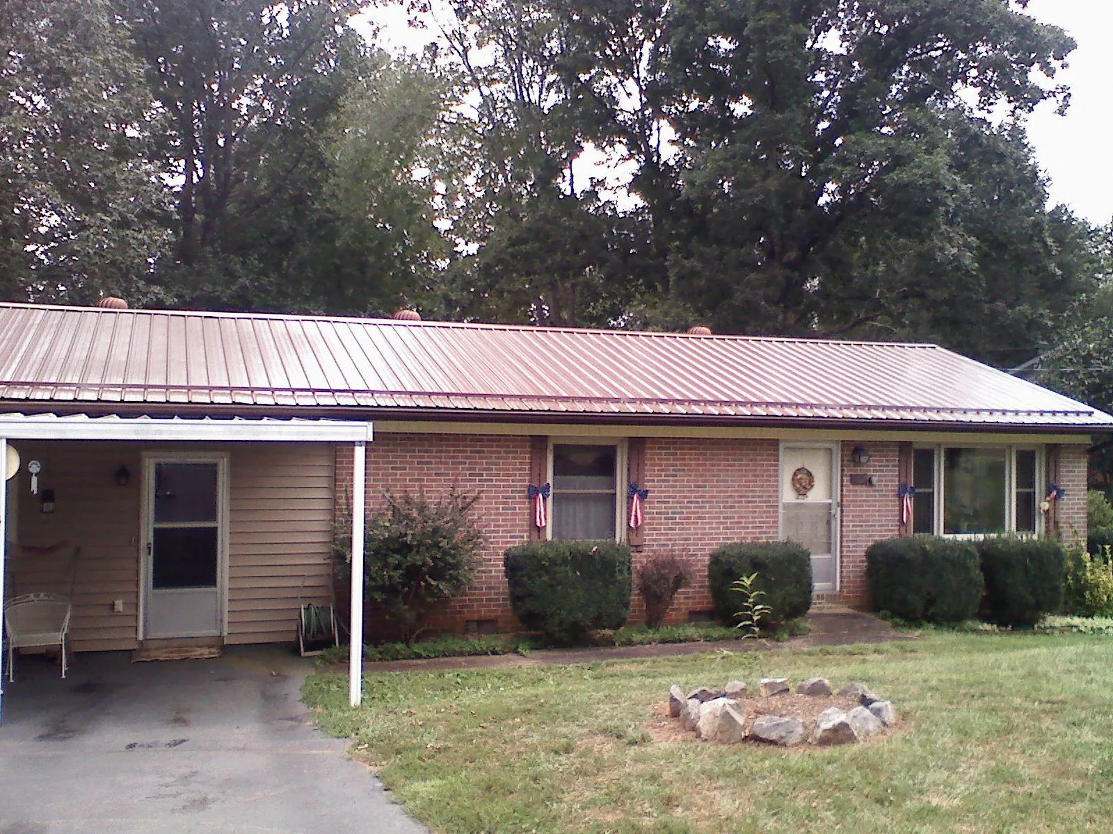 Bronze metal roof and carport on a brick ranch home — Roof Repair work by our crew in Zeigler
